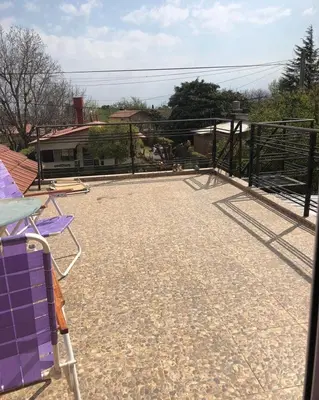 a large patio with purple chairs on a roof at Lodelore in Merlo