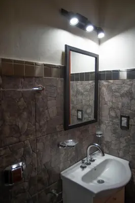 a bathroom with a sink and a mirror at La Chuklla, alojamiento cerca al lago in Almafuerte