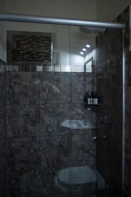 a bathroom with a glass shower with a sink at La Chuklla, alojamiento cerca al lago in Almafuerte