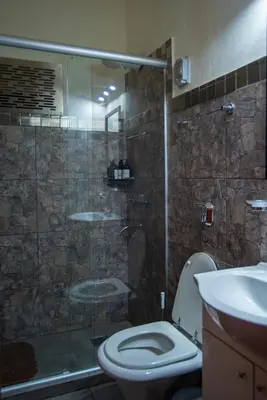 a bathroom with a shower and a toilet and a sink at La Chuklla, alojamiento cerca al lago in Almafuerte