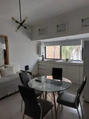 a living room with a glass table and chairs at RaGi dpto 3 in Cordoba