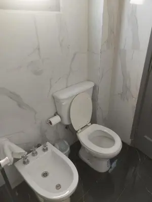 a white bathroom with a toilet and a sink at RaGi dpto 3 in Cordoba