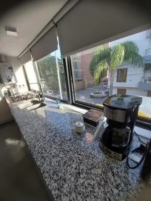 a kitchen counter with a coffee maker on a granite counter top at RaGi dpto 3 in Cordoba