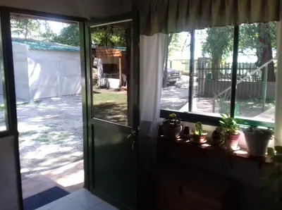 an open door to a yard with potted plants at Posada A Lo De Santys in Villa Independencia