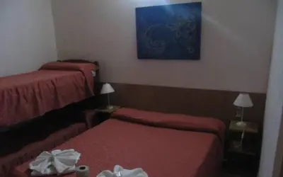 a hotel room with two beds and a painting on the wall at Posada A Lo De Santys in Villa Independencia