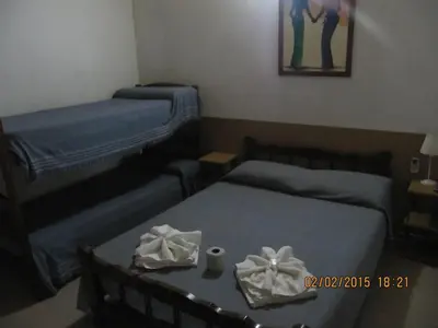 a room with two beds and a table with towels at Posada A Lo De Santys in Villa Independencia