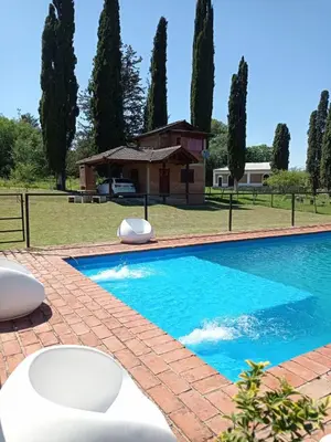 a swimming pool in front of a house at Un lugar en el Mundo in Villa Amancay
