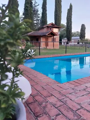 a swimming pool in front of a house at Un lugar en el Mundo in Villa Amancay