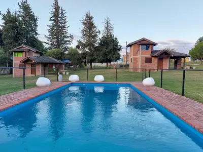 a swimming pool in a yard with a house at Un lugar en el Mundo in Villa Amancay