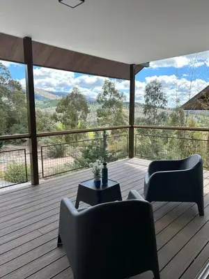 a living room with two chairs and a table on a deck at La cumbrecita ,Casitas super lujo in La Cumbrecita
