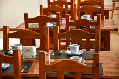 a wooden table with cups and saucers on it at Altos de Brochero Cabañas & Padel in Villa Cura Brochero