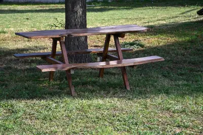 a wooden picnic table sitting next to a tree at Altos de Brochero Cabañas & Padel in Villa Cura Brochero