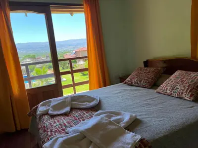 a bedroom with a bed and a large window at Altos de Brochero Cabañas & Padel in Villa Cura Brochero