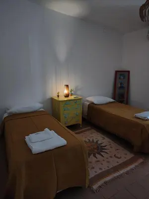 a room with two beds and a table with a candle at Mística in Alta Gracia