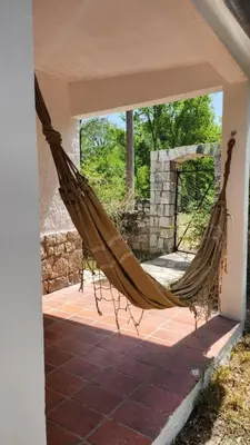 a hammock on a patio with a stone fireplace at Mística in Alta Gracia
