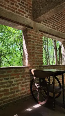 a picnic table in a brick room with two windows at Mística in Alta Gracia