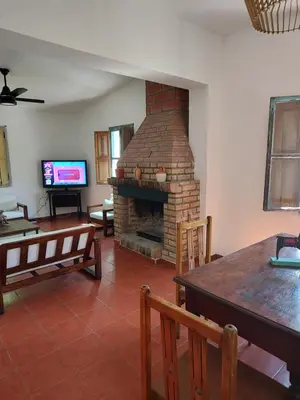 a living room with a brick fireplace and a television at Mística in Alta Gracia