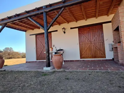 a house with two wooden doors and a brick patio at Las Masias de Nono in Nono