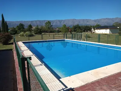 a large blue swimming pool with a fence at Las Masias de Nono in Nono