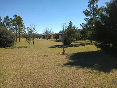 a field with trees and a building in the background at Las Masias de Nono in Nono