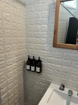 a bathroom with three bottles on a wall next to a sink at Alma mia in Villa Carlos Paz