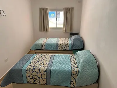 two beds in a small room with a window at La Nonita in Villa Carlos Paz
