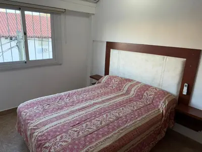 a bedroom with a bed with a blanket on it at Costalago in Villa Carlos Paz