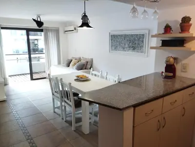 a kitchen and dining room with a table and a couch at Dpto Eiffel Nueva Córdoba in Cordoba