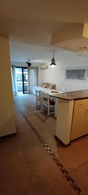 a kitchen and living room with a table and chairs at Dpto Eiffel Nueva Córdoba in Cordoba
