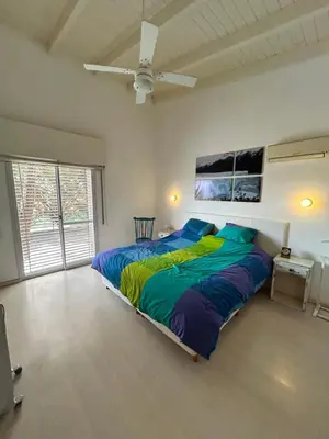 a bedroom with a large bed with a colorful comforter at Casa La Loma in Los Reartes