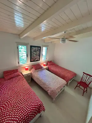 two beds in a room with red and white sheets at Casa La Loma in Los Reartes