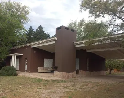 a large brown building with acovered at Casa La Loma in Los Reartes