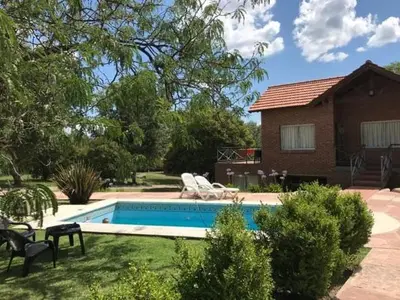 a swimming pool in front of a house at Loszorritos in Merlo