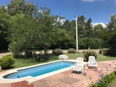 a swimming pool with two white chairs next to it at Loszorritos in Merlo