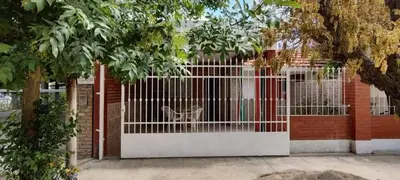 a white gate with a cat inside of it at Mi casita de la suerte in Villa Cura Brochero