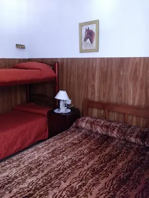 a bedroom with two beds and a lamp on a table at Mi casita de la suerte in Villa Cura Brochero