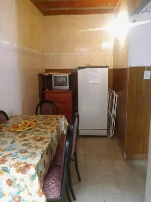 a dining room with a table and a refrigerator at Mi casita de la suerte in Villa Cura Brochero