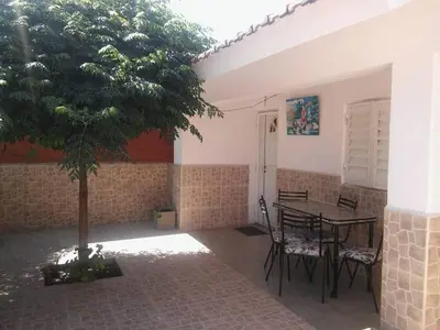 a patio with a table and chairs and a tree at Mi casita de la suerte in Villa Cura Brochero