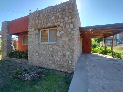 a stone house with a stone wall at Cabañas Juan in Arroyo de Los Patos