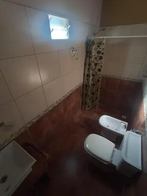 a bathroom with a toilet and a sink and a window at Cabañas Juan in Arroyo de Los Patos