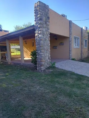 a house with a stone pillar in front of it at Cabañas Juan in Arroyo de Los Patos