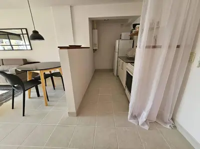 a small kitchen with a table and a refrigerator at Gran Ubicacion Guemes in Cordoba