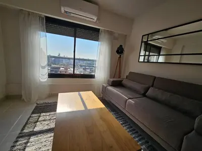 a living room with a couch and a large window at Gran Ubicacion Guemes in Cordoba