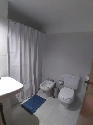 a white bathroom with a toilet and a sink at Gran Ubicacion Guemes in Cordoba