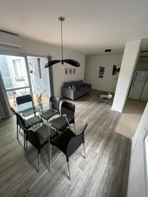 a living room with a glass table and black chairs at Depto carlos paz in Villa Carlos Paz