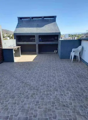 a patio with a table and a chair on a roof at Depto carlos paz in Villa Carlos Paz