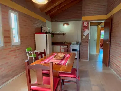 a kitchen and dining room with a table and chairs at Las Magnolias - Casas de Campo in Mina Clavero