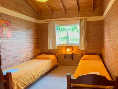 a bedroom with two beds and a window at Las Magnolias - Casas de Campo in Mina Clavero