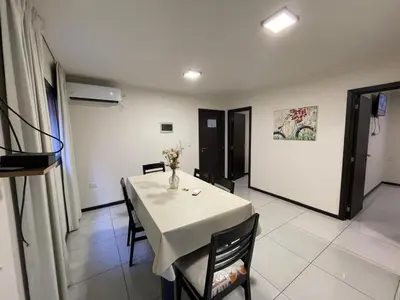 a dining room with a table with a vase of flowers on it at DEPARTAMENTO EN ALQUILER TEMPORAL Ubicado en Villa Carlos Paz in Villa Carlos Paz
