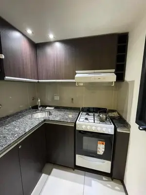 a kitchen with a stove and a sink at DEPARTAMENTO EN ALQUILER TEMPORAL Ubicado en Villa Carlos Paz in Villa Carlos Paz